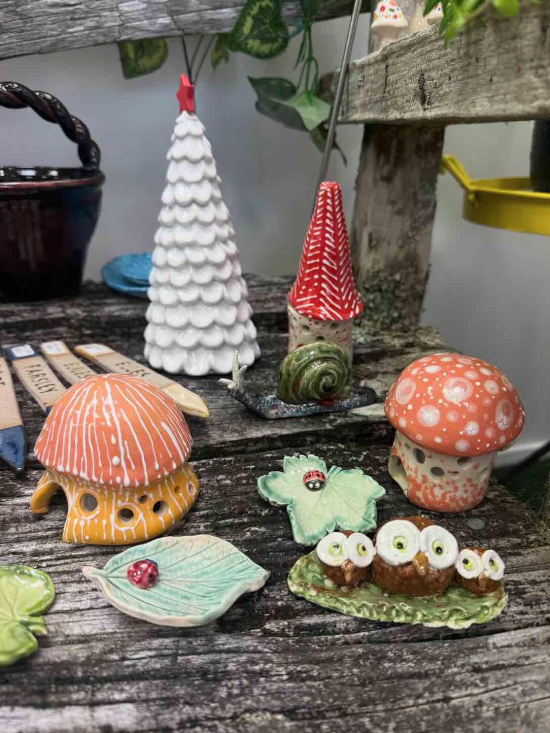 Selection of bowls, mugs, jewellery, and small ceramic works on stepped display tables