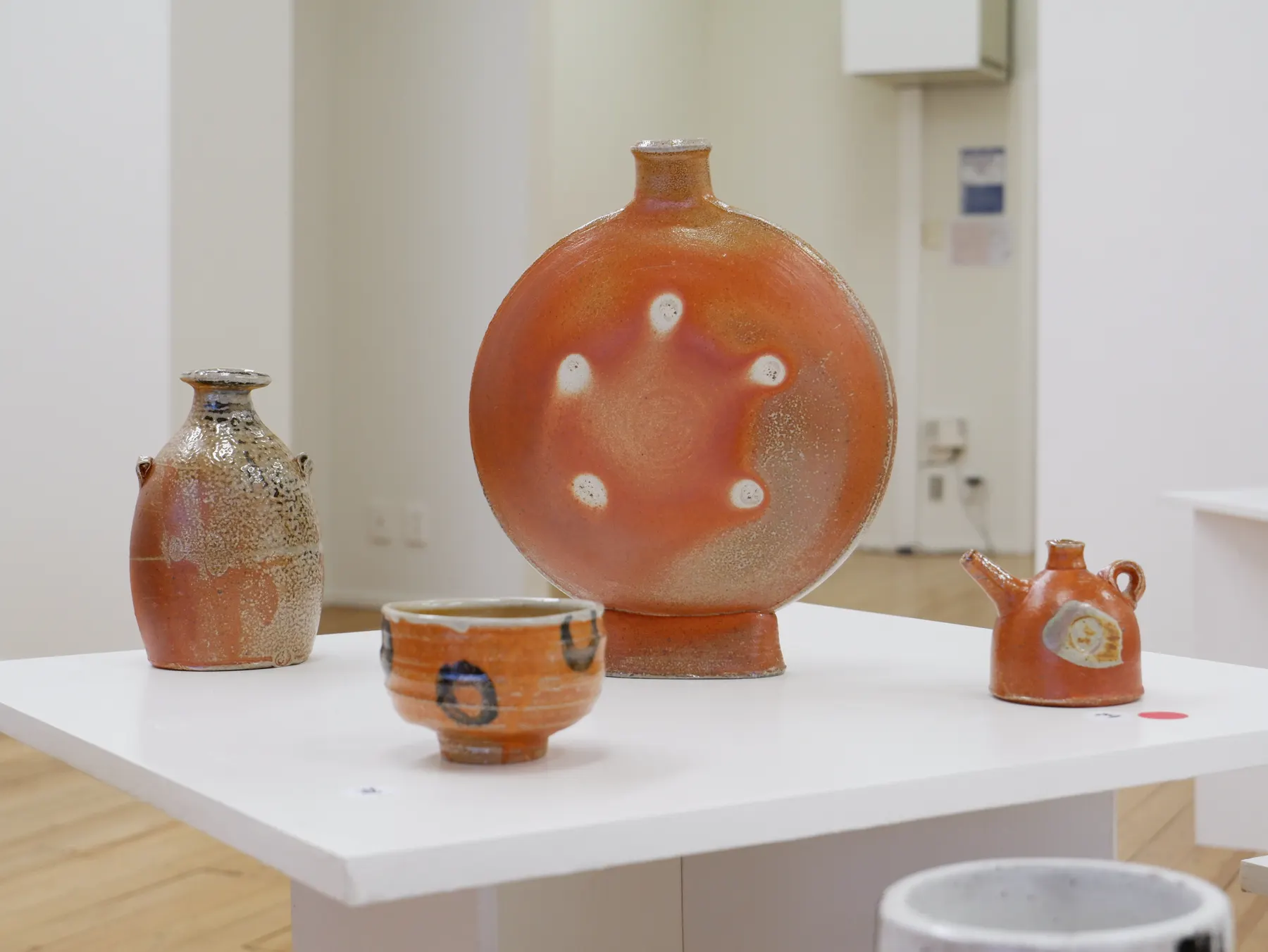 Wood-fired sculptural ceramics displayed together on a white table